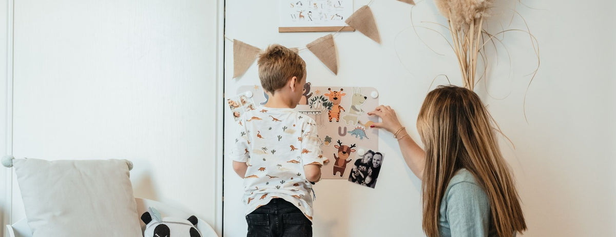 Un enfant et sa mère en train de jouer sur un tableau magnétique