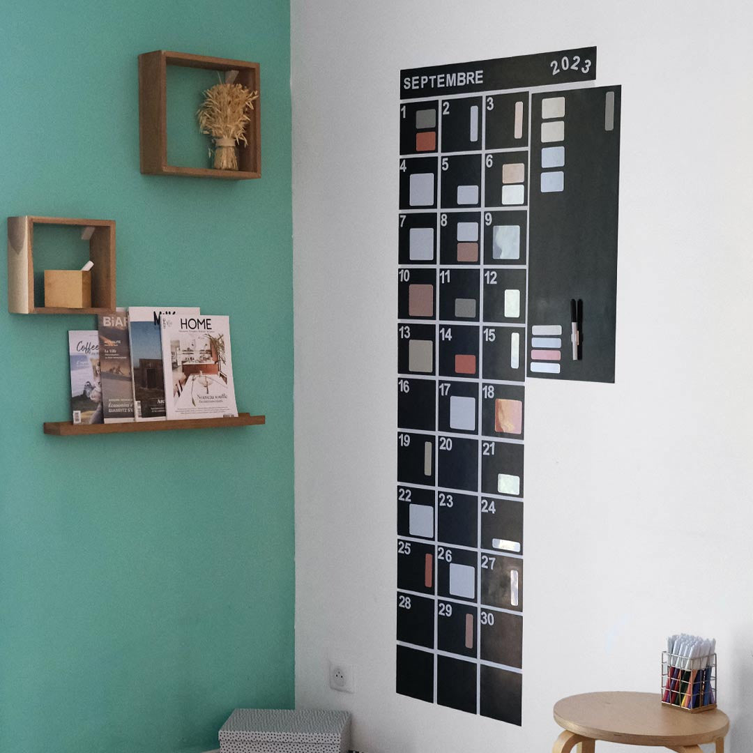 Calendrier mensuel magnétique format vertical accroché au mur du salon