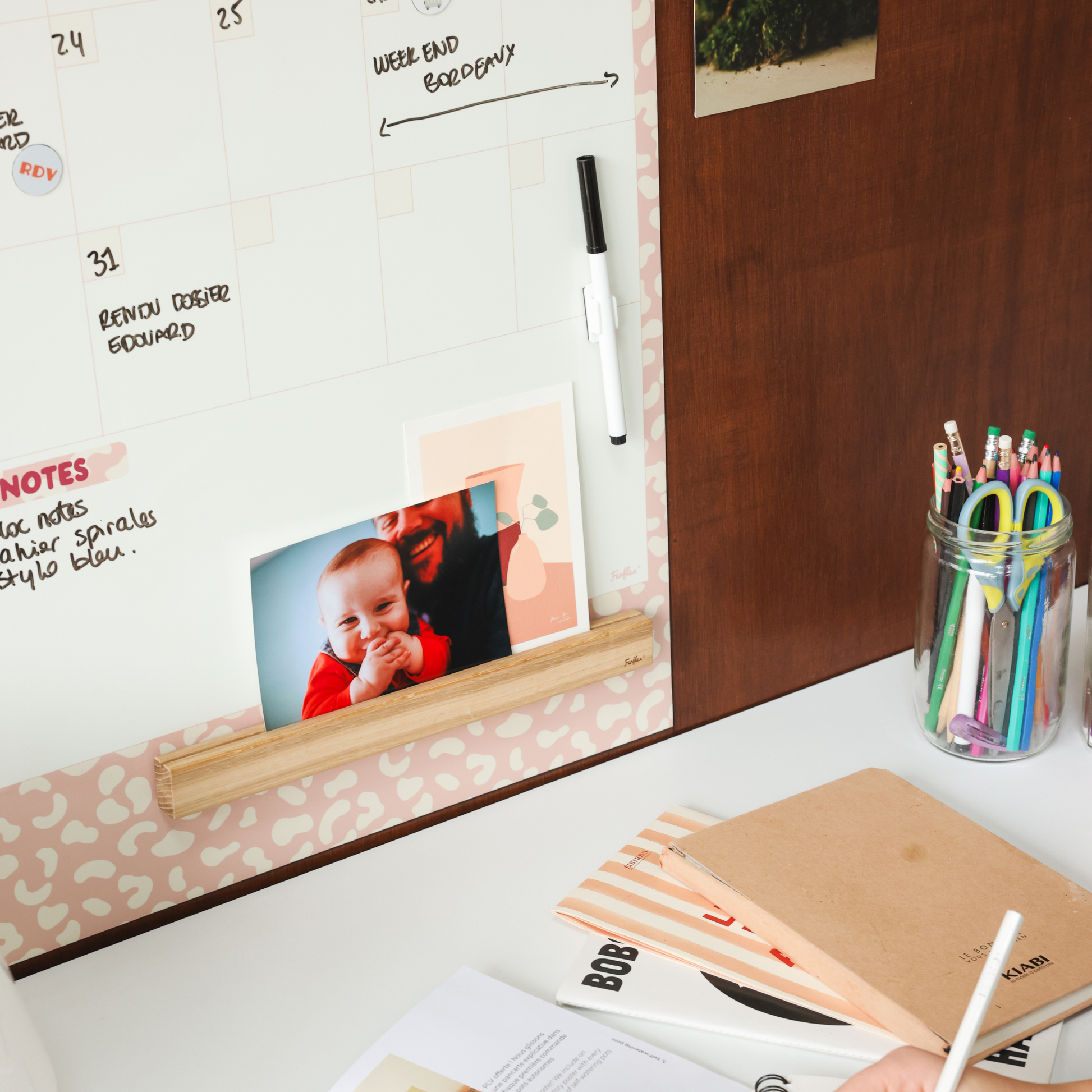 Planning mensuel magnétique avec notes manuscrites et magnets décoratifs.