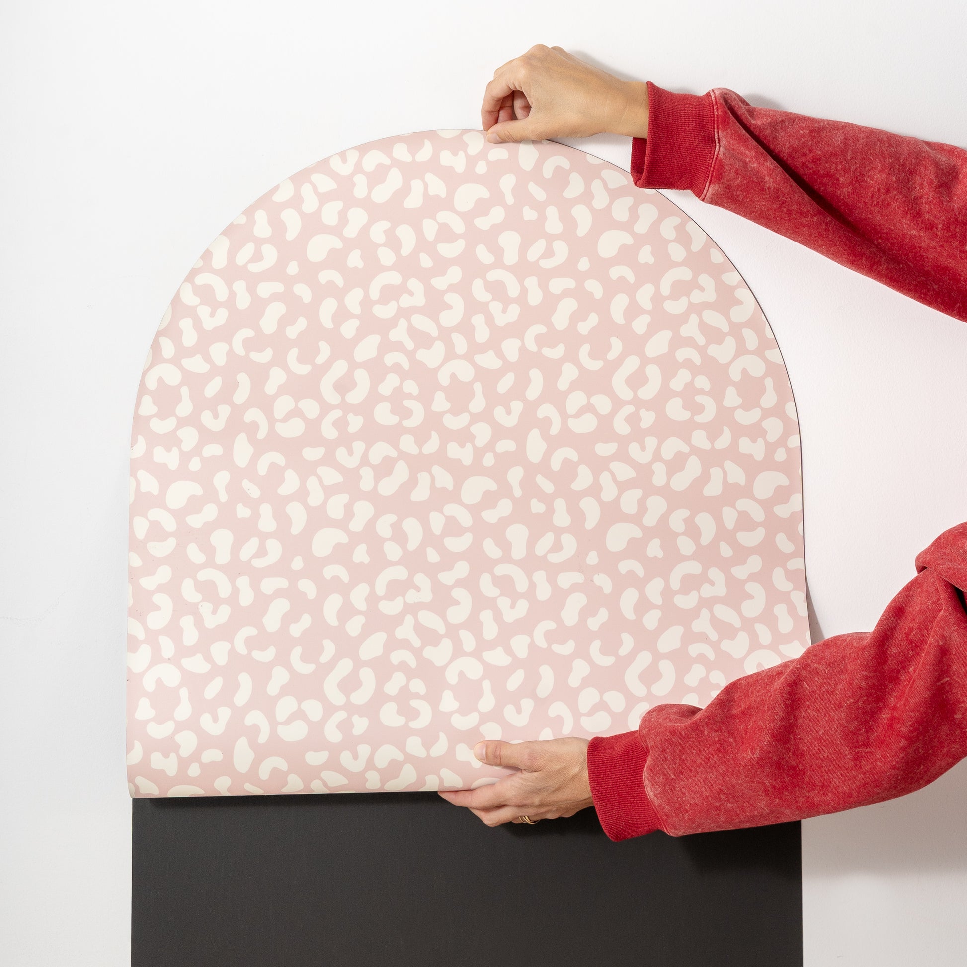 Revêtement imprimé léopard en train d'être positionné sue le tableau magnétique noir arche