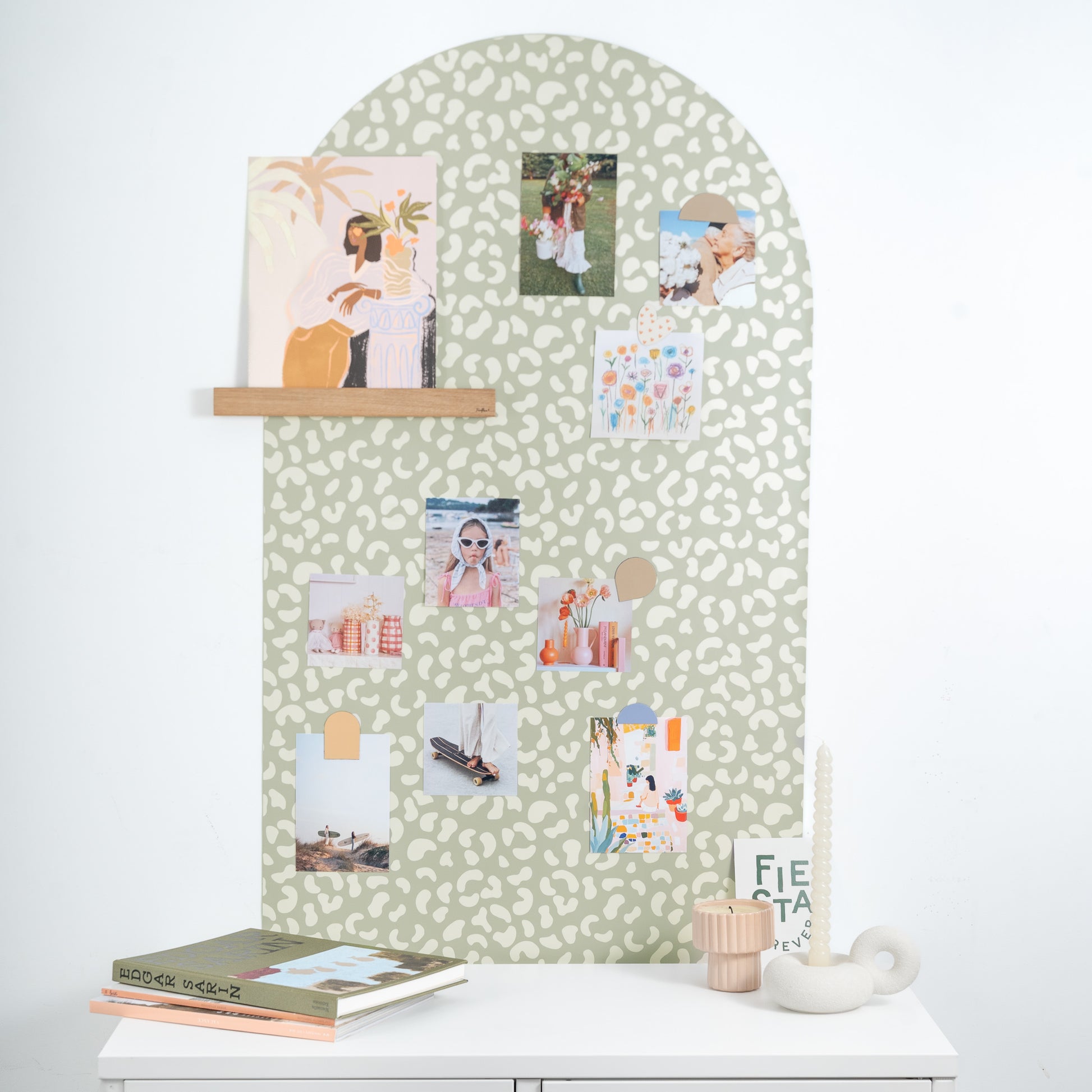 Tableau magnétique mural imprimé léopard vert avec photos et affiche posée sur une étagère magnétique en bois 