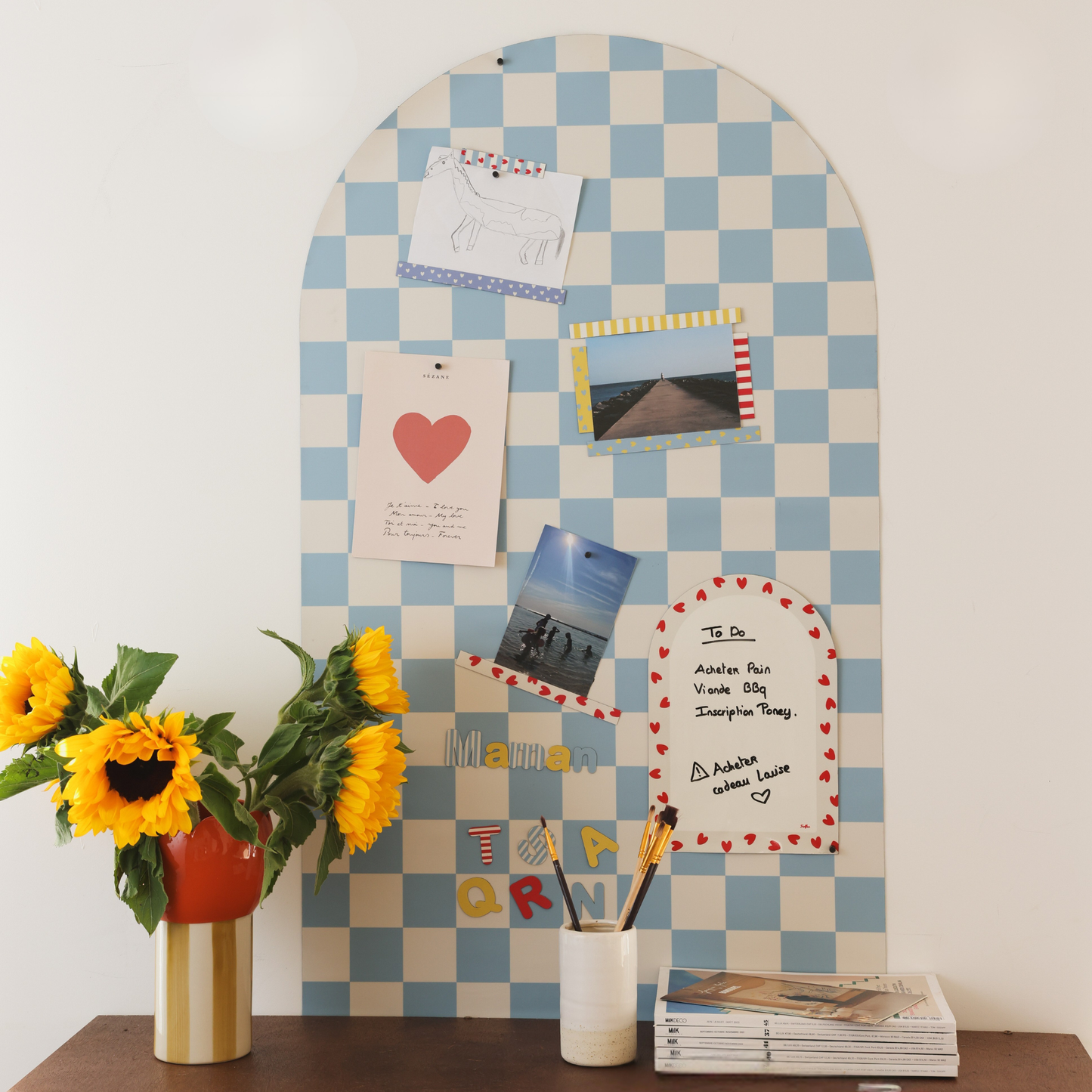 Tableau magnétique mural damier bleu Ferflex® au-dessus d'une commode, pour afficher photos, cartes et pense-bêtes 