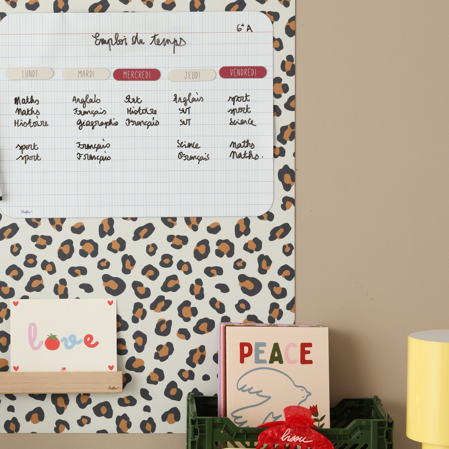 Gros plan emploi du temps scolaire effaçable à sec sur tableau magnétique rectangle léopard avec étagère photos bois Ferflex® 