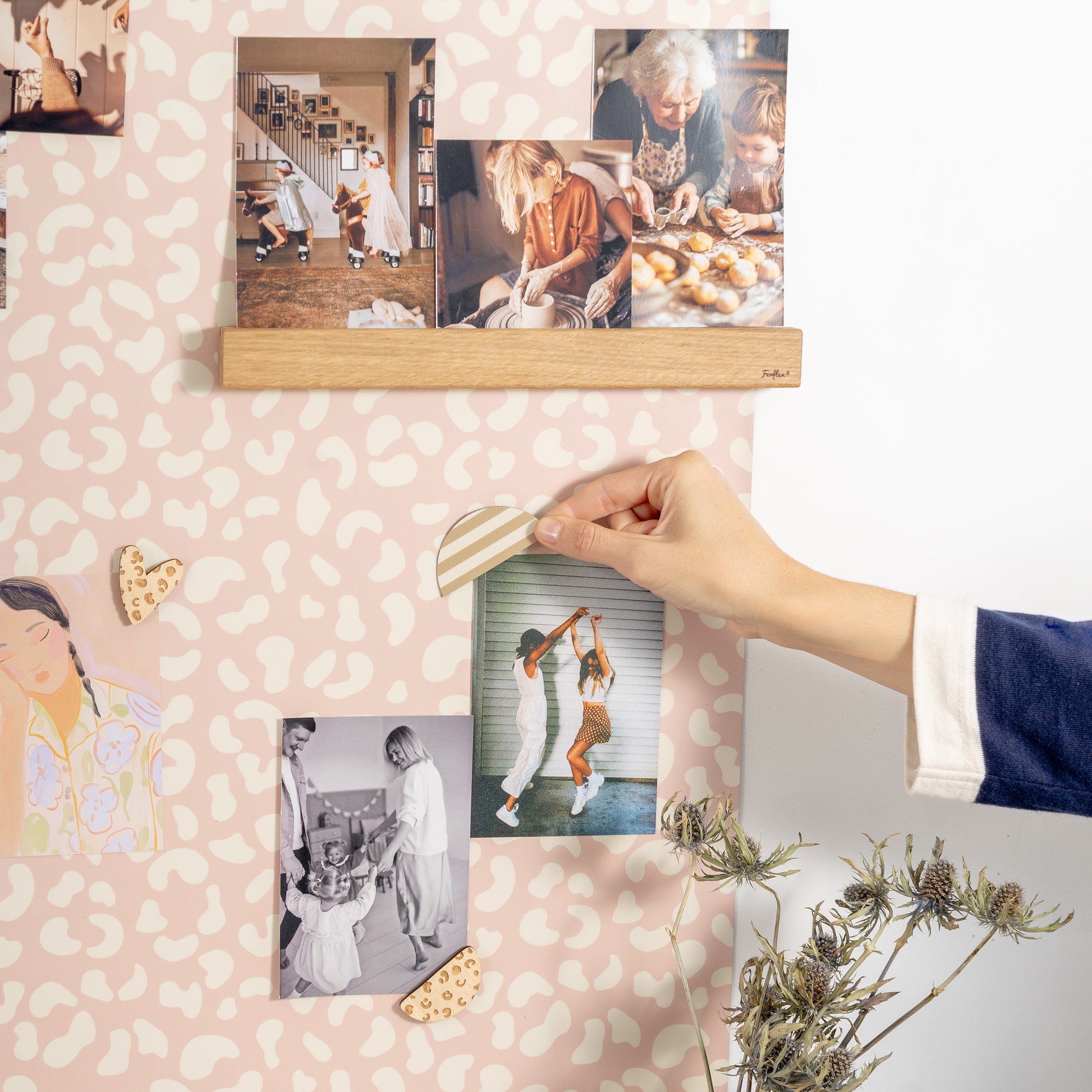 Main positionnant un magnets pour afficher une photo sur un tableau magnétique arche 