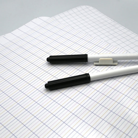 Deux feutres effaçables posés sur les ardoises d'écriture réglées et quadrillées