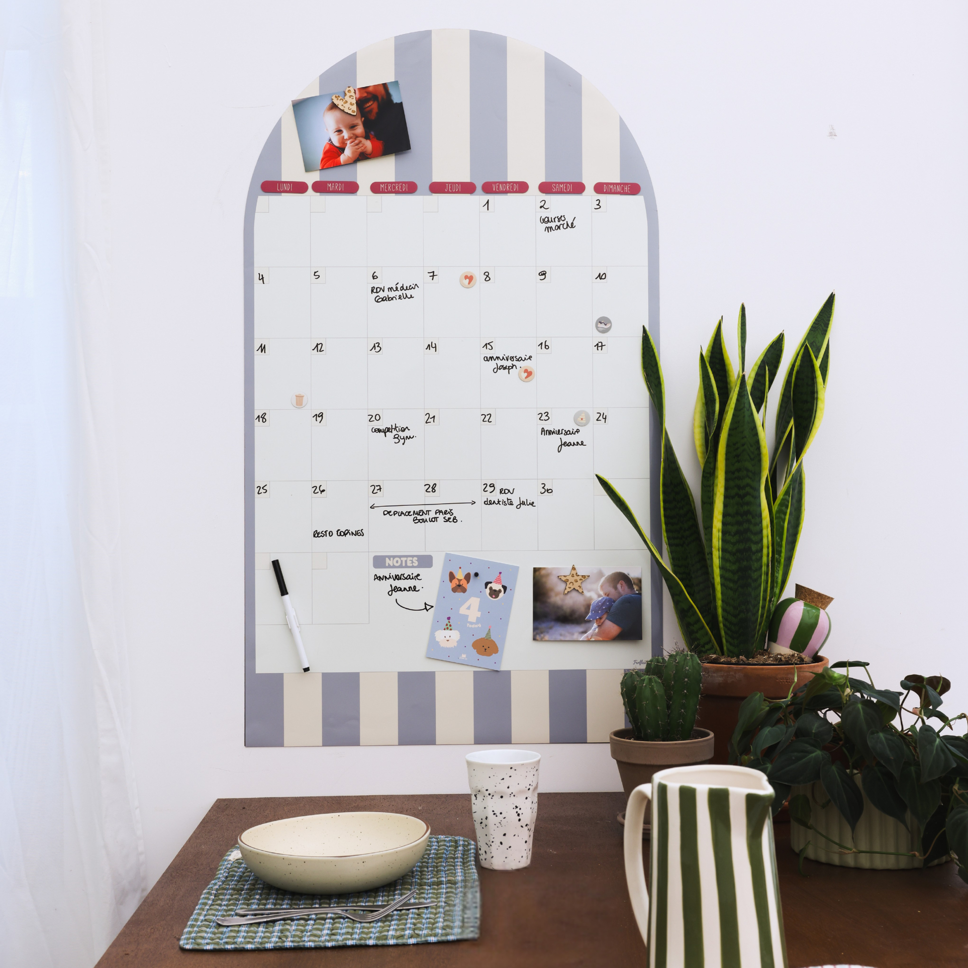 Calendrier mural magnétique mensuel arche rayée installé dans une cuisine