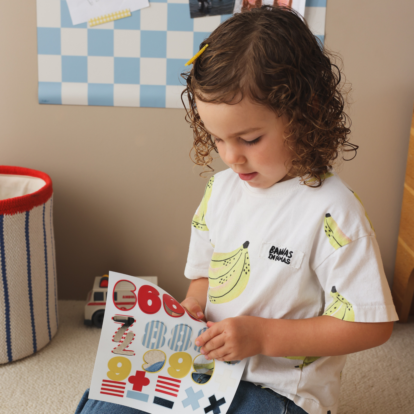 Petite fille détachant les magnets chiffres colorés pour apprendre à compter