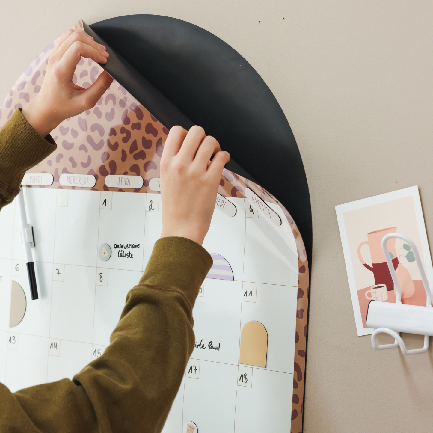Installation du calendrier magnétique en forme d’arche coloris camel.