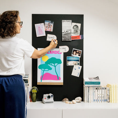 Femme qui écrit sur un pense-bête magnétique posé sur un papier peint magnétique 