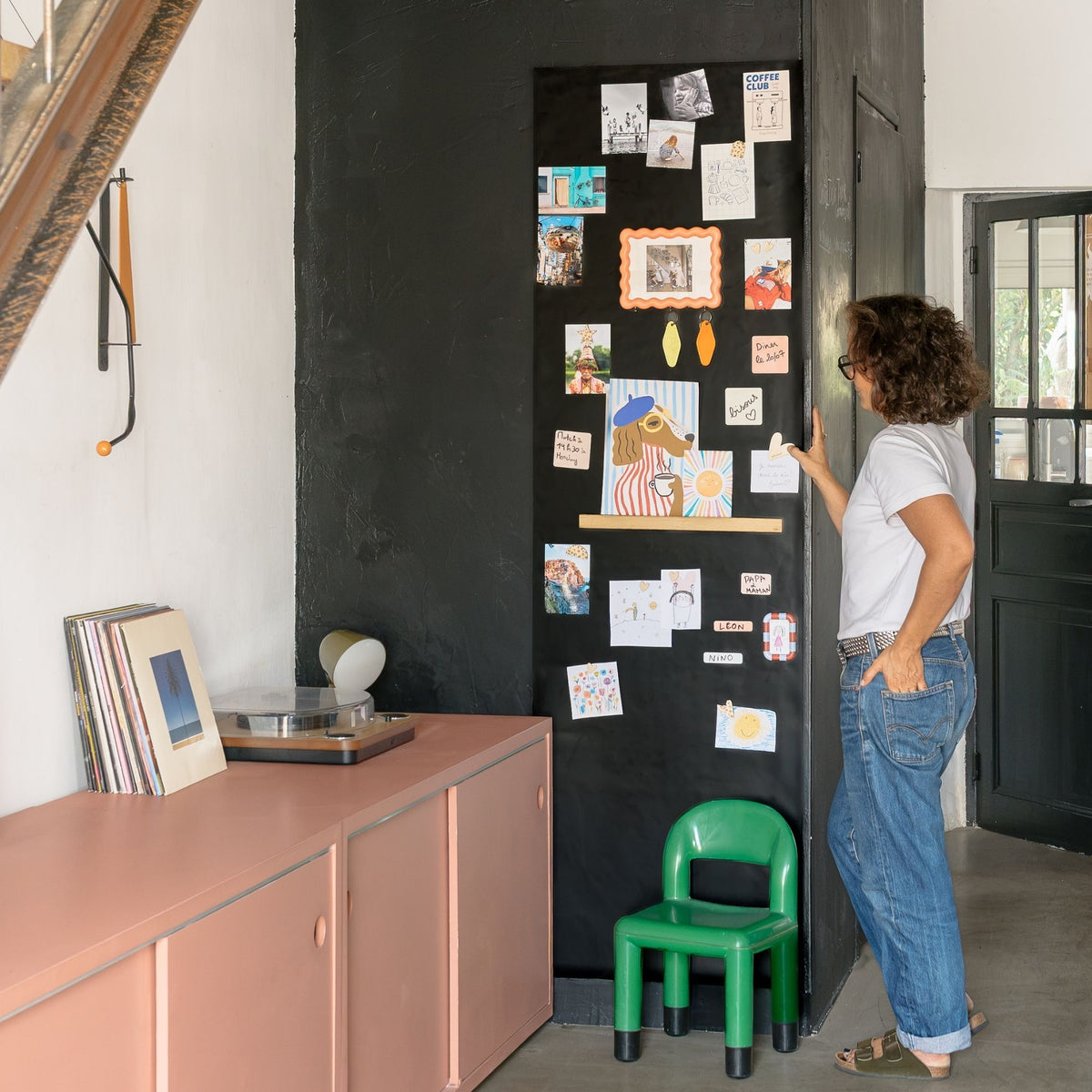 Papier peint magnétique grand format dans un salon avec pense-bêtes magnétiques, photos et dessins d'enfant