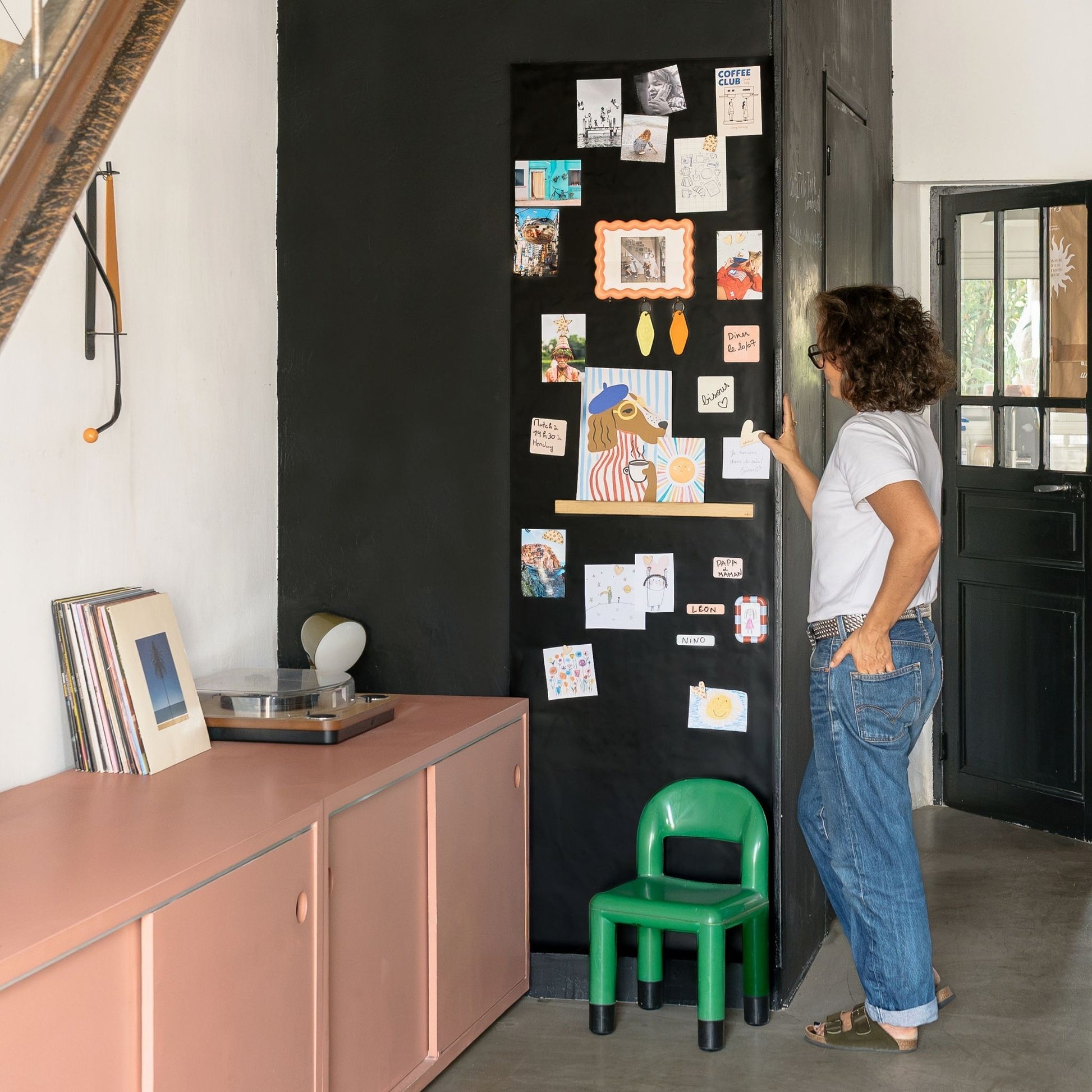 Papier peint magnétique grand format dans un salon avec pense-bêtes magnétiques, photos et dessins d'enfant