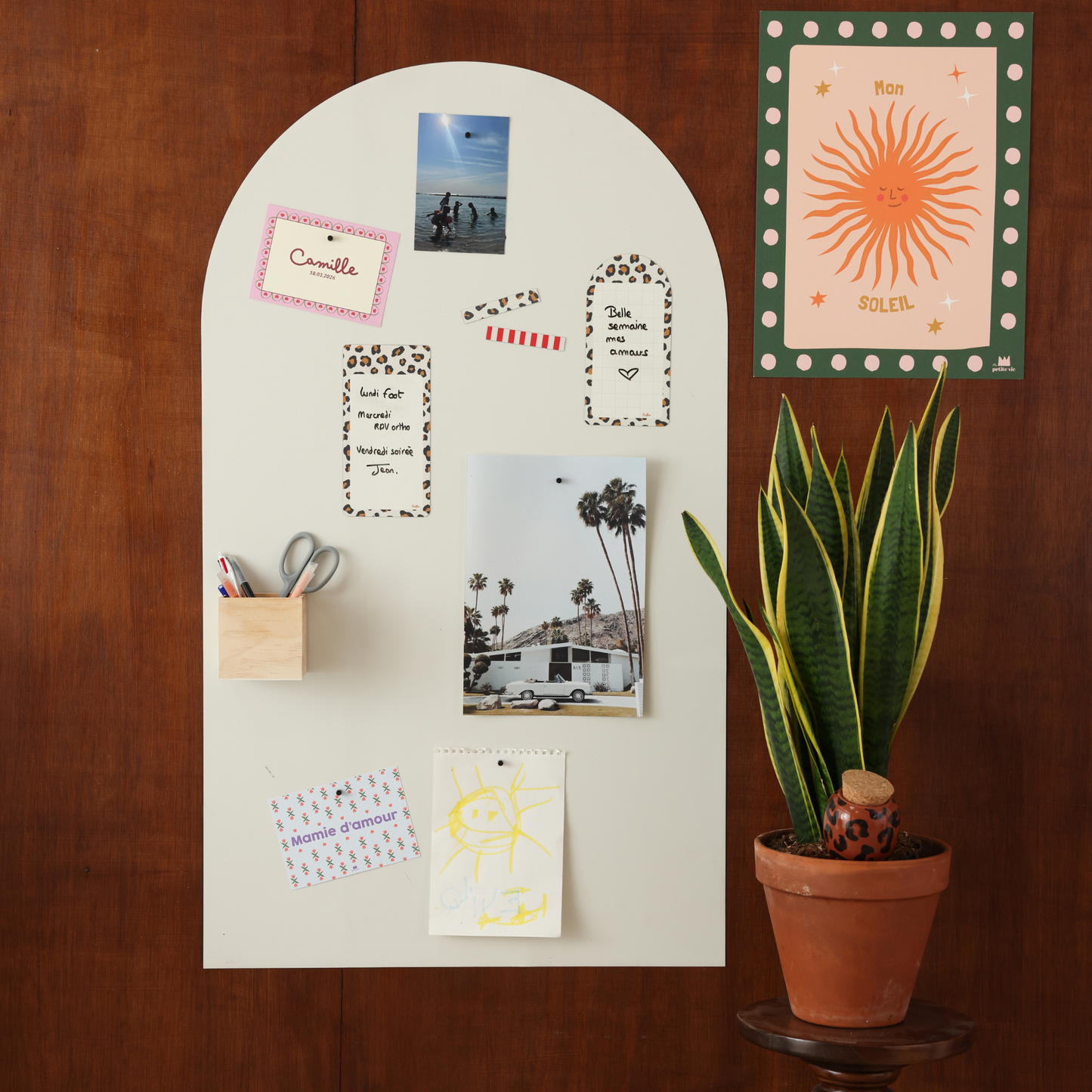 Tableau magnétique arche beige lin grand format posé sur un mur en bois avec photos et accessoires aimantés décoratifs
