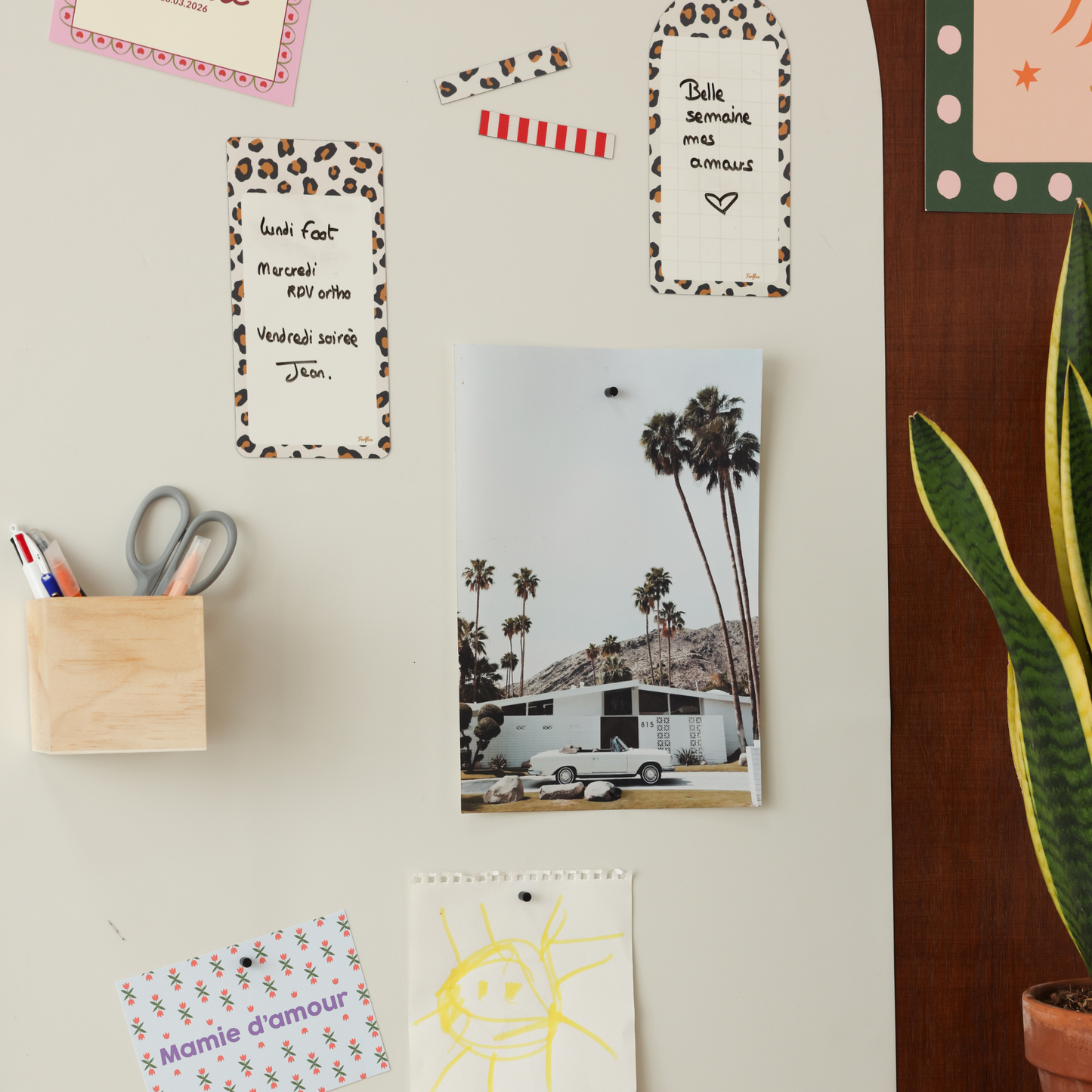 Zoom sur un tableau magnétique arche beige lin avec pense-bêtes léopard, masking tape et photos 