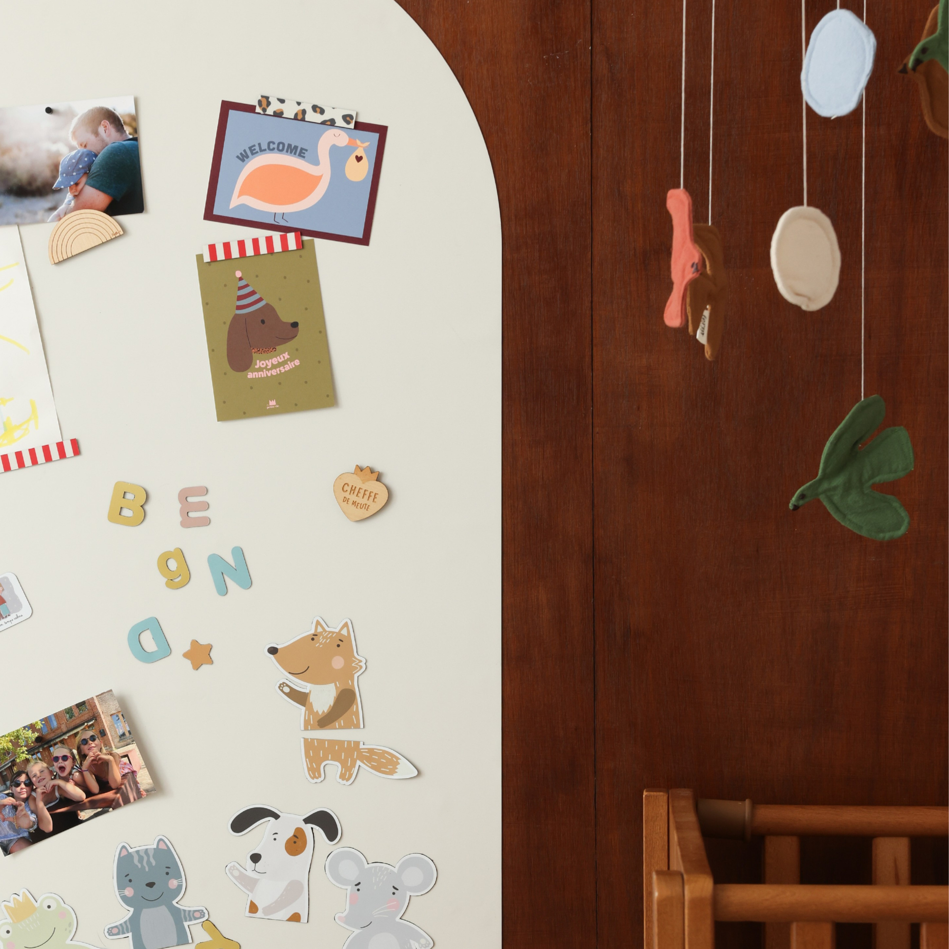 Tableau mural en forme d'arche beige lin dans une chambre enfant avec puzzle animaux magnétique et cartes