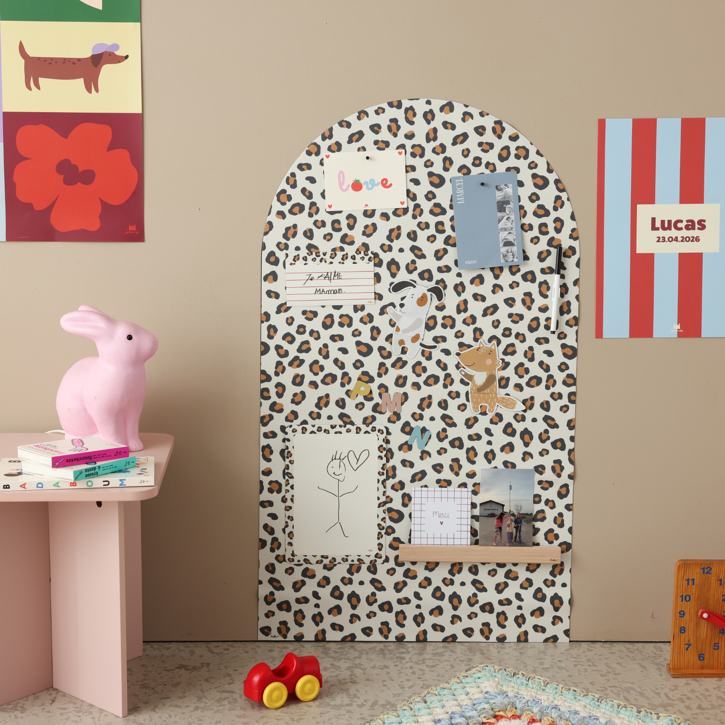 Grand tableau magnétique arche léopard dans une chambre d'enfant colorée avec jeux magnétiques, dessins et photos