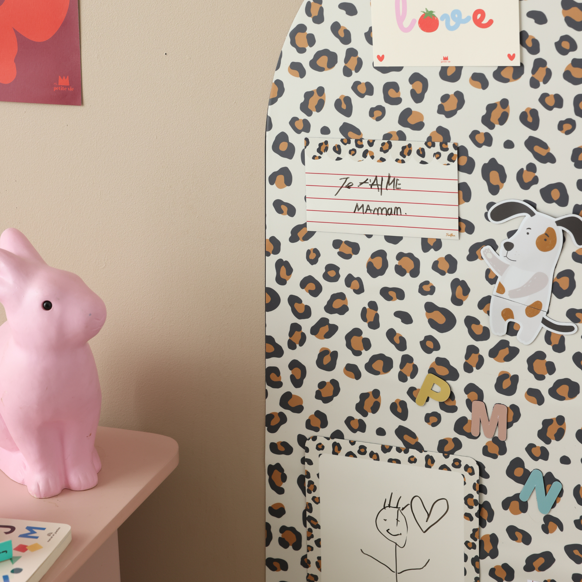 Tableau magnétique arche léopard dans un espace enfant avec lettres magnétiques, dessins et pense-bêtes magnétiques